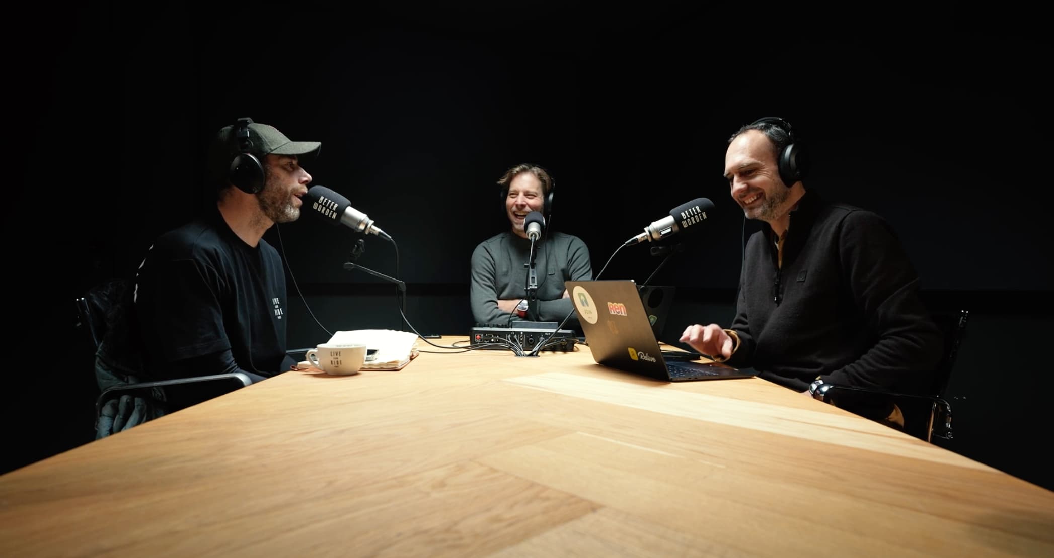 Podcast recording session with three hosts at a wooden table
